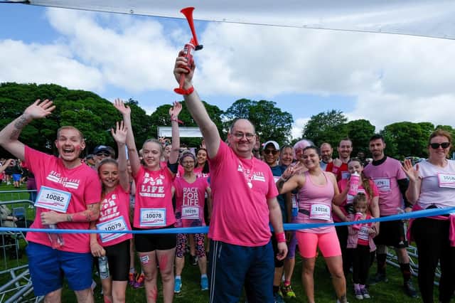 Cancer survivor Brett Hadley prepares to sound the starter's horn at the Race for Life 2022 event in Graves Park, Sheffileld