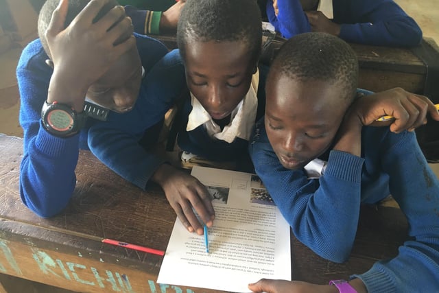 Kilema Primary pupils reading letters sent by St. Mary's pupils
