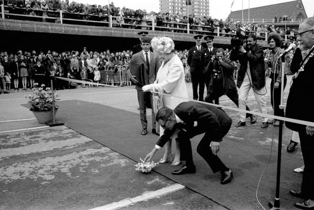 Queen Elizabeth the Queen Mother drops her posy when she cuts the ribbon to open the Kingston Bridge, June 1970. Councillor William Hunter picks it up.
