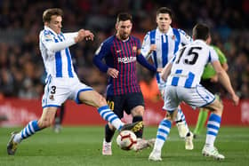 Barcelona's Argentinian forward Lionel Messi (C) is tackled by Real Sociedad's Spanish defender Diego Llorente (L) during the Spanish league football match between FC Barcelona and Real Sociedad at the Camp Nou stadium in Barcelona: PAU BARRENA/AFP via Getty Images)