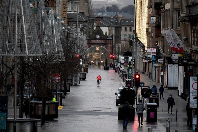 Members of the public walk through the city centre as new Covid rules come into place on January 5, 2021 in Glasgow, Scotland.