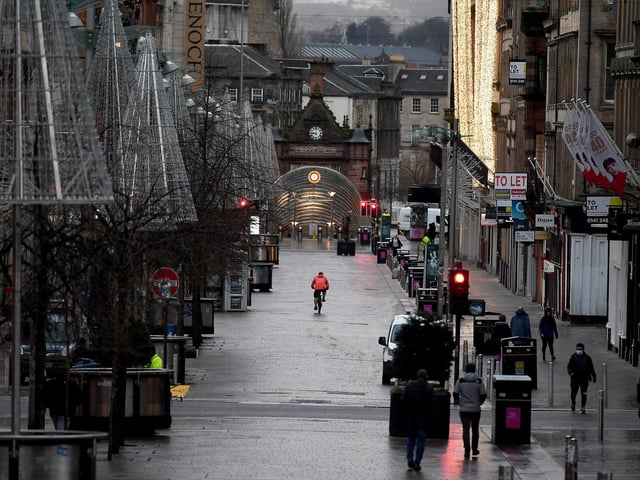Members of the public walk through the city centre as new Covid rules come into place on January 5, 2021 in Glasgow, Scotland.