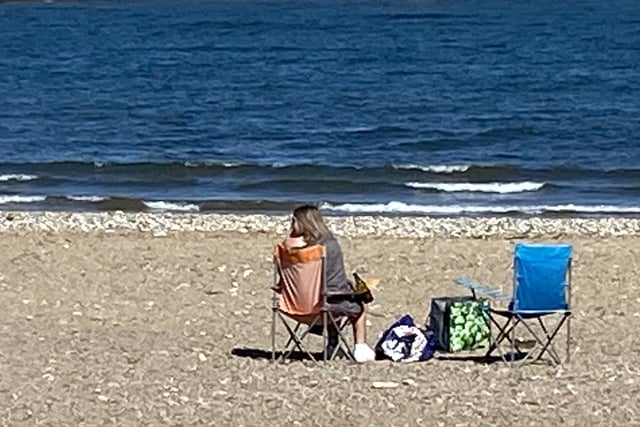 A woman enjoys the view from her quiet picnic spot.