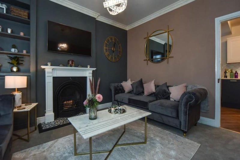 Front-facing, furnished in soft colours with the fireplace being the main focus.