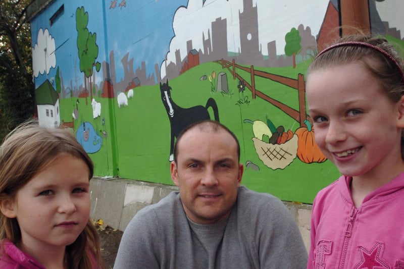 Artist Richard Chippington shows a mural he painted at the farm to young visitors Ella Hanna (7) and Isabel Pritchard (9) in October 2007