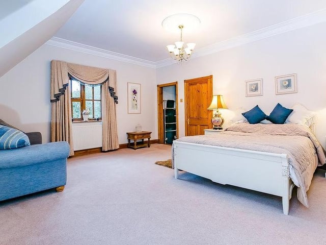 The master bedroom includes a large, walk-in dressing-room. There are also fitted wardrobes running down two sides of the room