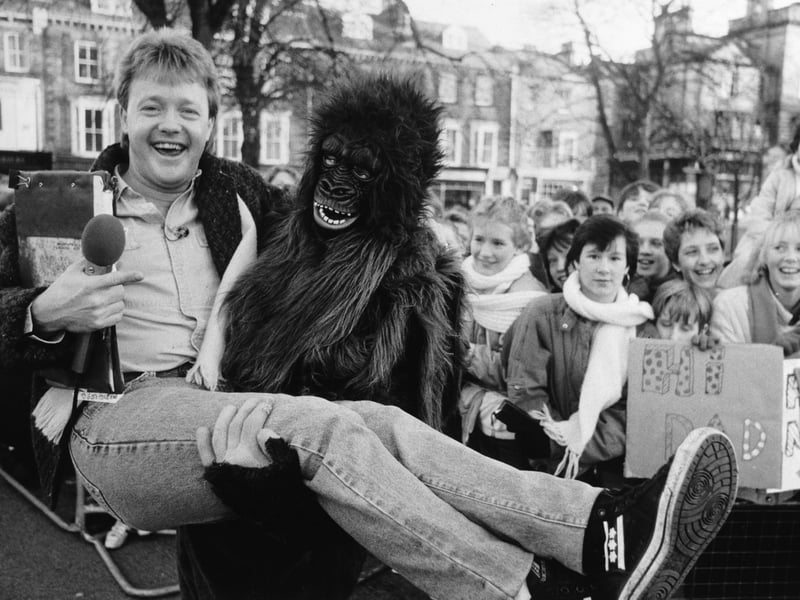 Saturday Superstore presenter Keith Chegwin gets a lift from ape man Jason Pitt during the BBC TV show's visit to Harrogate in 1985