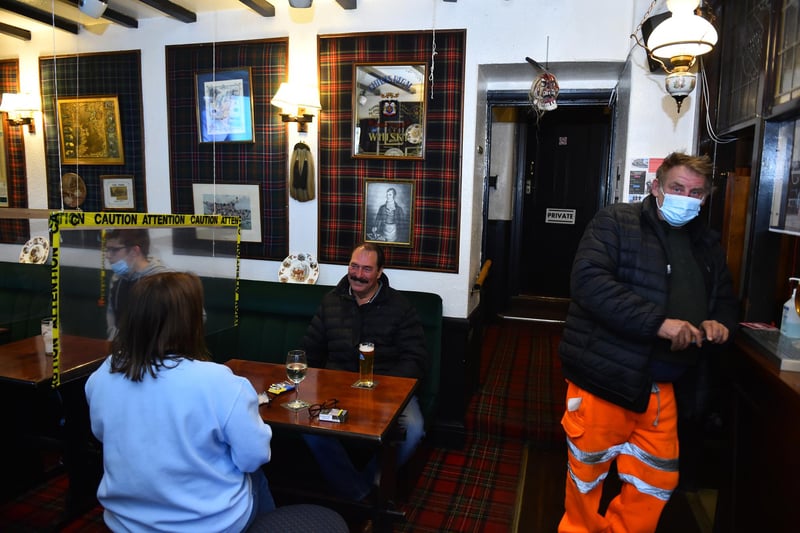 People enjoy a drink at The Swan Inn pub. (Photo by Nathan Stirk/Getty Images)