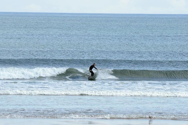 A surfer rides the waves at Seaburn Beach.