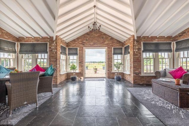 Leading directly off this open plan area is a triple aspect garden room, which boasts a vaulted ceiling, exposed brickwork and views over the rear gardens and open fields beyond