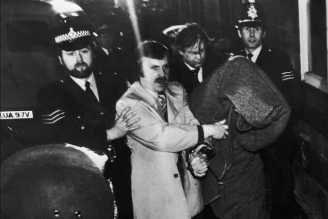 Under a blanket, Sutcliffe being taken to Dewsbury Magistrates' Court in January 1981 to be charged with murder