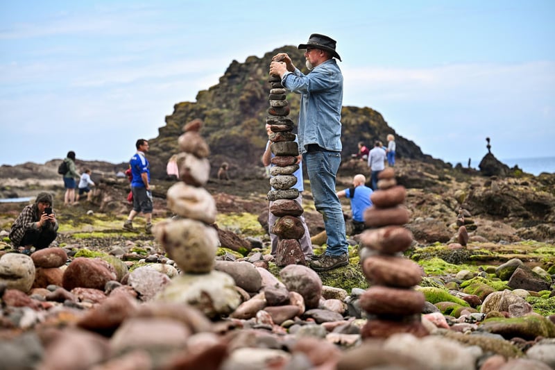 One of the artists competing in the event builds an impressive tower with stones of rocks.