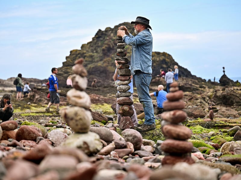 One of the artists competing in the event builds an impressive tower with stones of rocks.
