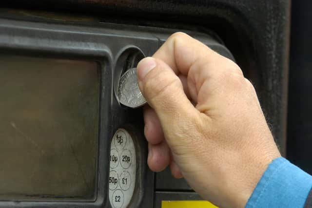 Money being inserted into a car park meter in Sheffield City Centre