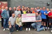 The Silver Foxes present their cheque to St Luke's fundraiser Ellie Matthews