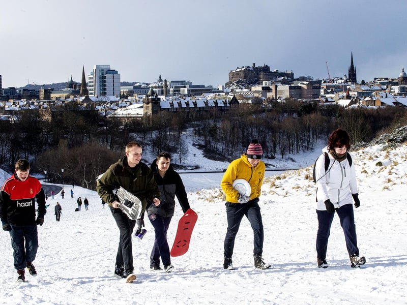 Snowboarders climb Arthur's Seat for a chance to enjoy the snow.