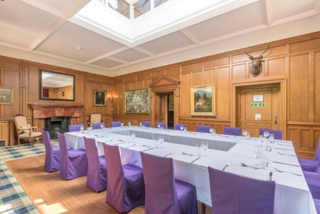The dining room has an open fireplace with a marble surround, wood panelling to dado height, an external door to the roof terrace, a crockery cupboard and an access door to a serving kitchen