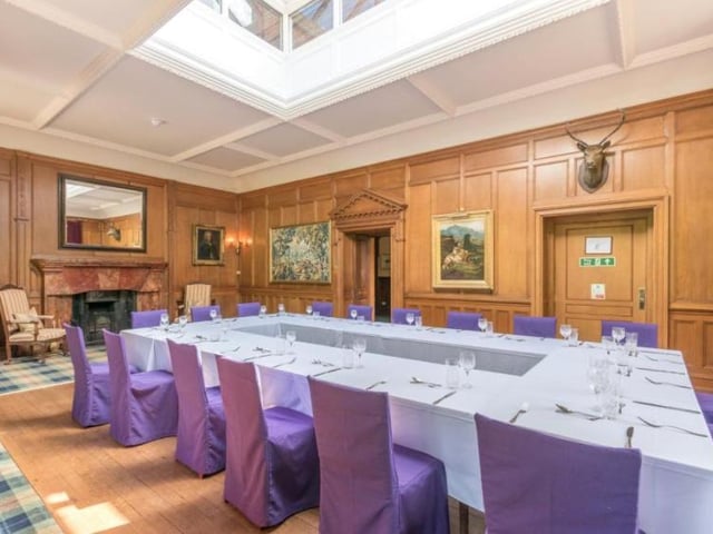The dining room has an open fireplace with a marble surround, wood panelling to dado height, an external door to the roof terrace, a crockery cupboard and an access door to a serving kitchen