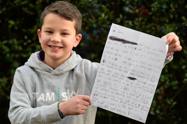 Theo Thompson, eight, pictured with the letter he has written to Boris Johnson.