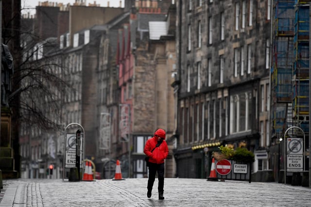 Members of the public walk through a deserted Edinburgh City Centre
