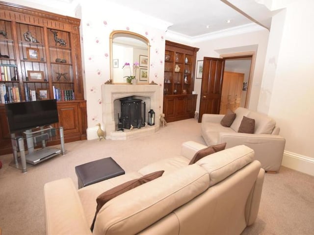 This second shot of the living room shows the feature fireplace in all its glory - as well as two magnificent, bespoke bookcases in fitted alcoves, which are decorative focal points.
