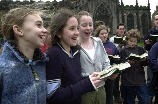Cathedral choir members sing outside Sheffield Cathedral.