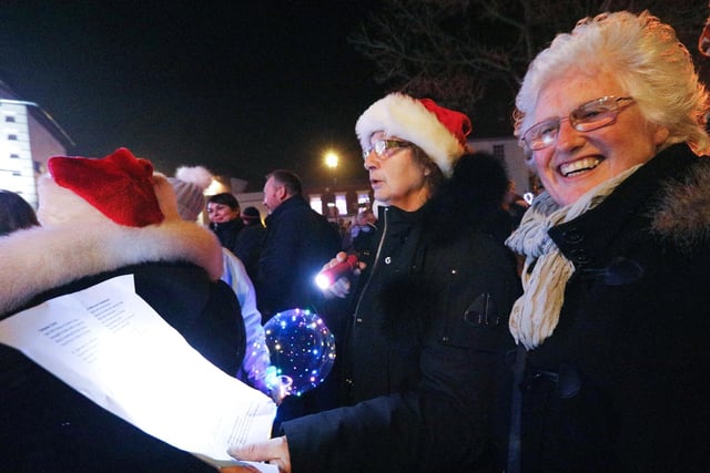Sheila Ballard, left, and Yvonne Ferguson sing carols by torchlight. Emsworth Christmas lights switch on, St Peter's Square, Emsworth
Picture: Chris Moorhouse   (jpns 031221-48)