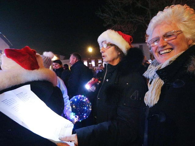 Sheila Ballard, left, and Yvonne Ferguson sing carols by torchlight. Emsworth Christmas lights switch on, St Peter's Square, Emsworth
Picture: Chris Moorhouse (jpns 031221-48)