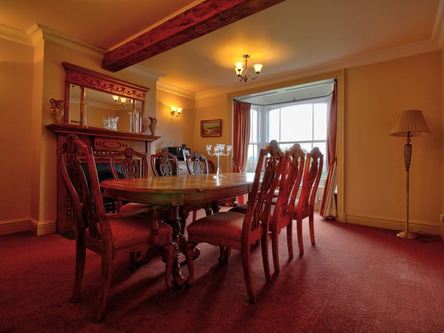 Cast iron fireplace with solid wood surround, original beams to the ceiling and bay sash windows.