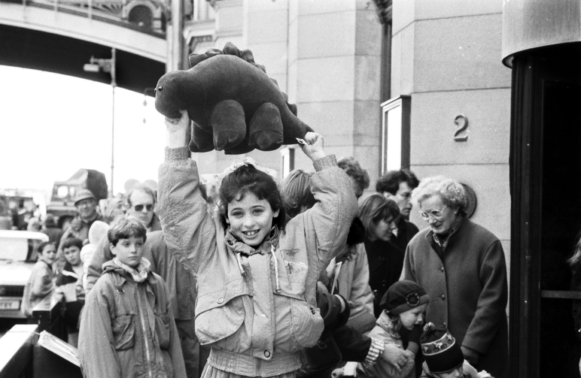 Iona Somerville wins a cuddly stegasaurus for being the 100,000th visitor to the Dinosaurs Alive! exhibition at the City Art Centre Edinburgh, April 1990.