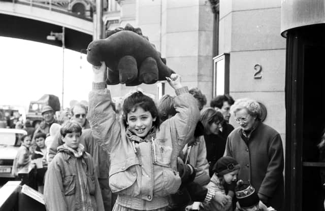 Iona Somerville wins a cuddly stegasaurus for being the 100,000th visitor to the Dinosaurs Alive! exhibition at the City Art Centre Edinburgh, April 1990.