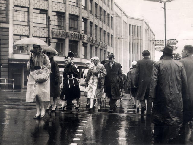 Sheffield folk head to work in the city centre on a wet morning on October 21, 1959.