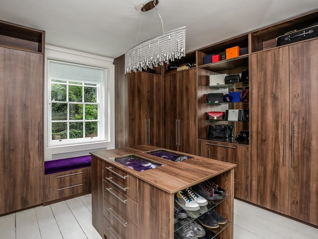 A "superbly" fitted space with an extensive range of wardrobes, drawers and shelving. Built in window seat and dressing table.