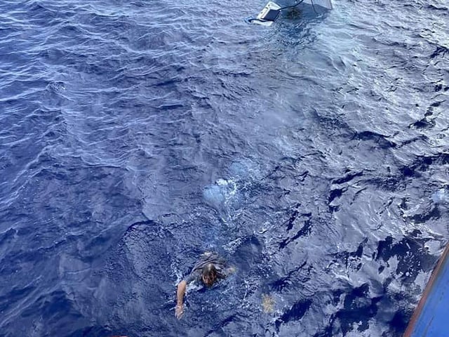 Stuart Bee, swims toward a life preserver as he is rescued by the crew aboard the U.S. Coast Guard.