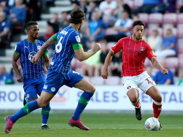 WIGAN, ENGLAND - SEPTEMBER 21: Macauley Bonne of Charlton Athletic runs with the ball under pressure from Charlie Mulgrew of Wigan Athletic during the Sky Bet Championship match between Wigan Athletic and Charlton Athletic at DW Stadium on September 21, 2019 in Wigan, England. (Photo by Lewis Storey/Getty Images)
