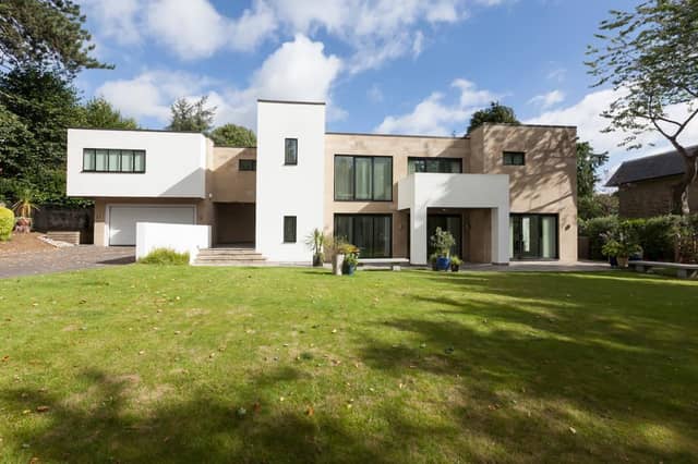 Sedum House sits back from Dore Road - oak intercom-operated gates open to the front of the property, where there is a block-paved driveway with mature trees, shrubs, and exterior lighting.