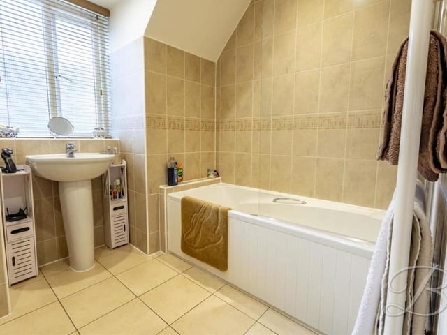Like all the rooms in the £395,000 Mansfield home, the family bathroom is presented to a high standard. It comprises a panelled bath, chrome 'waterfall' shower, pedestal sink, low-flush WC and window to the side.
