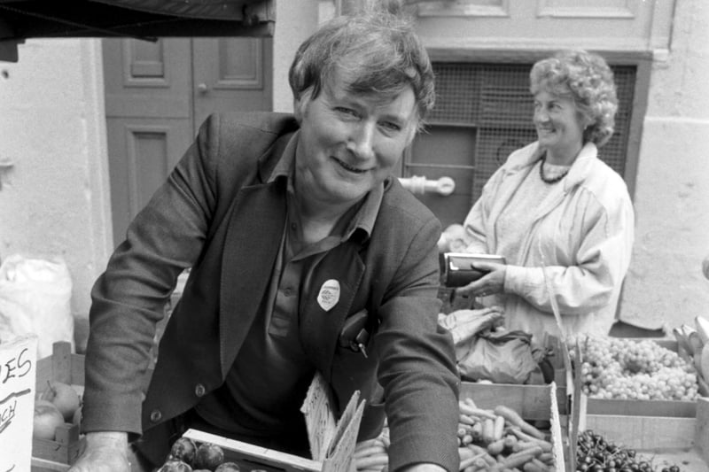 Fresh fruit and vegetable seller Willie Blues serves a customer some nectarines from his stall in Infirmary Street in Edinburgh in August 1986.