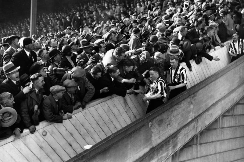 Newcastle United are congratulated by fans on their way down the steps at Wembley Stadium after the presentation of the FA Cup Trophy. Newcastle won the trophy with a 2-1 victory over Arsenal. The final proved controversial because of the referee's bad decision in counting their first goal, which resulted from a cross that was kicked from behind the dead ball line.