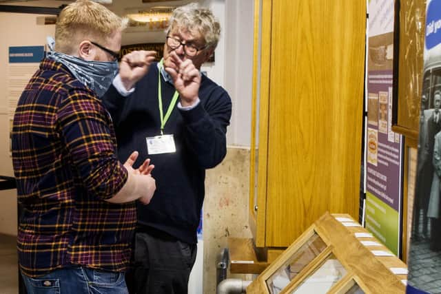 Keith Crawshaw talks to a visitor to demonstrate the archive on the screens at Kelham Island Museum