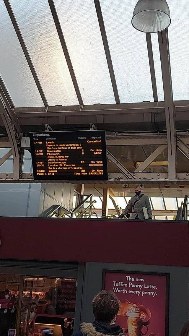A departure board at Sheffield station shows two trains that were cancelled due to a shortage of train crew.