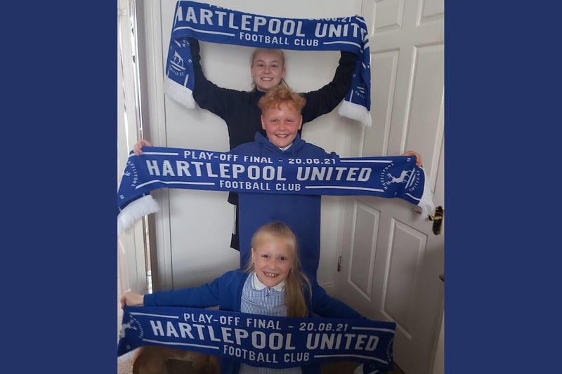 Three happy fans with their scarves.