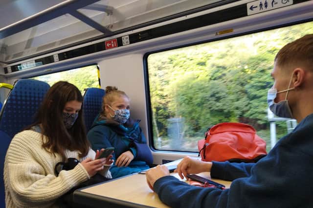 University of Sheffield students Jess, Daisy and Jacob wearing face masks on the train