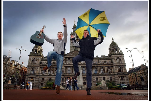 Charlie and Craig Reid of the Proclaimers get under a Glasgow umbrella to headline Hogmanay in the city in 2003.