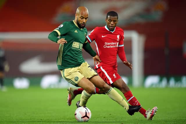 LIVERPOOL, ENGLAND - OCTOBER 24: David McGoldrick of Sheffield United is challenged by Georginio Wijnaldum of Liverpool during the Premier League match between Liverpool and Sheffield United at Anfield on October 24, 2020 in Liverpool, England. Sporting stadiums around the UK remain under strict restrictions due to the Coronavirus Pandemic as Government social distancing laws prohibit fans inside venues resulting in games being played behind closed doors. (Photo by Stu Forster/Getty Images)