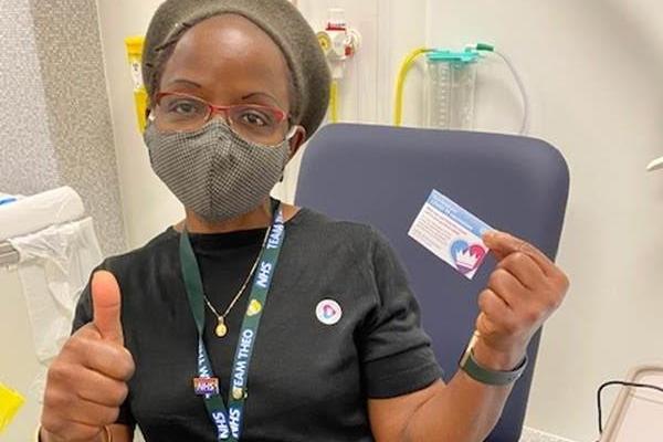 A member of staff shows her vaccination card after having her jab during the pandemic at Sheffield Sheffield Children's Hospital