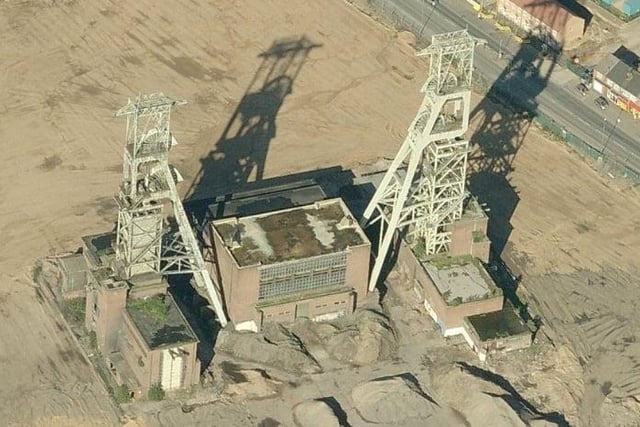 An aerial view of the headstocks showing the vegetation of the roof and many parts of the building covered with soil.