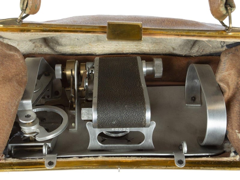 A Soviet KGB spy purse used by female operatives, designed to hold a concealed FED camera. An emblem on the side of the purse, shaped like a fly, opens up to allow the camera to capture an image. The purse, which is lined with Vataline material to conceal sound, has come to be known as "The Fly." Estimate: $2,000-$3,000.