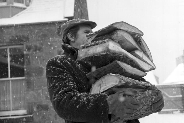 A Prestonpans miner carries logs to an OAP's home when coal stocks started to run low.