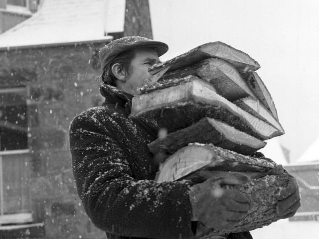 A Prestonpans miner carries logs to an OAP's home when coal stocks started to run low.